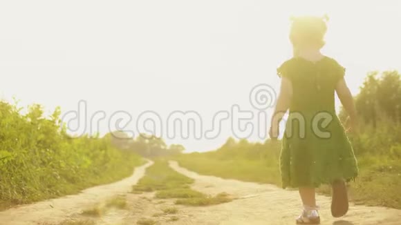 在阳光明媚的夏日傍晚Stadicam拍摄了一张小女孩在乡间小路上散步的照片视频的预览图