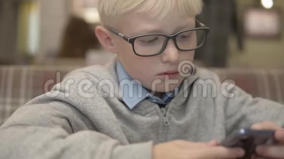 一个戴眼镜的男孩在手机上下棋视频的预览图