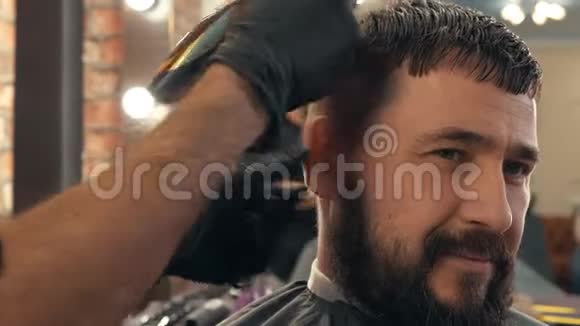 剪发的时候要把脸贴上胡子理发店里有电动剃须刀的男性发型使用修发师视频的预览图