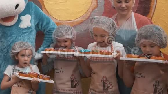 快乐的孩子们拿着托盘和美味的甜甜圈视频的预览图