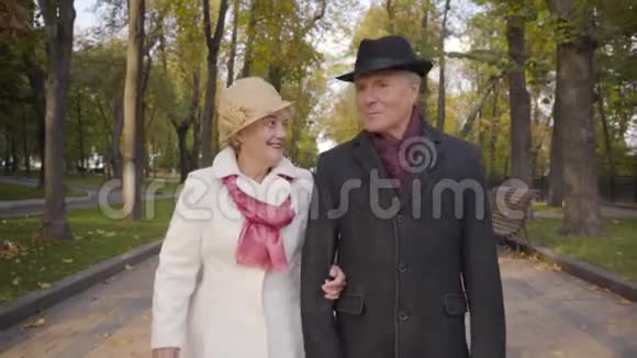 一对成熟的高加索夫妇在公园里度过了秋天穿着黑色外套和帽子的老人在和他说话视频的预览图