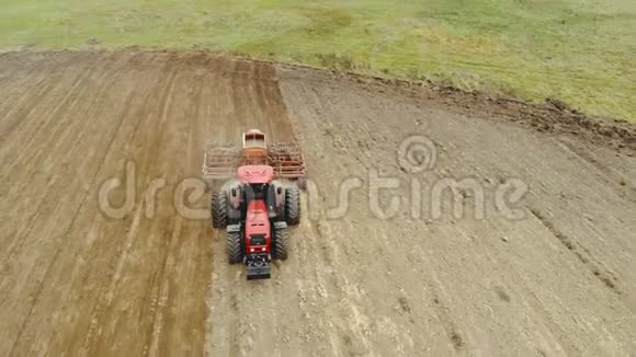 农夫开着一辆拖拉机装有一个容器用来播种春天在田间工作的粮食作物视频的预览图
