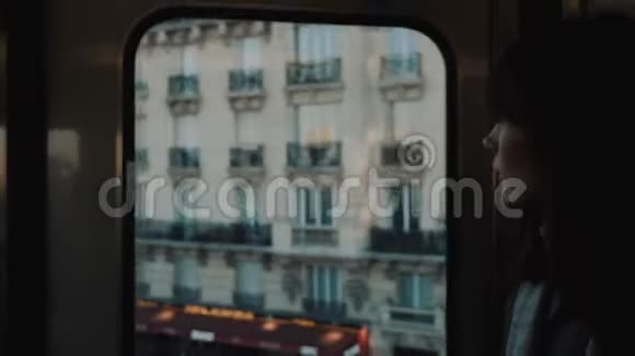 年轻的女游客在巴黎乘坐地铁看着令人惊叹的埃菲尔铁塔和街道上肮脏的窗户慢动作视频的预览图
