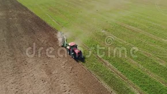 农民在红色拖拉机上犁满灰尘的干旱土壤视频的预览图