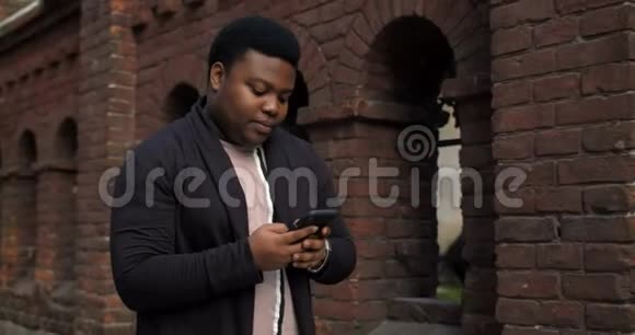 胖子用智能手机在街上散步视频的预览图