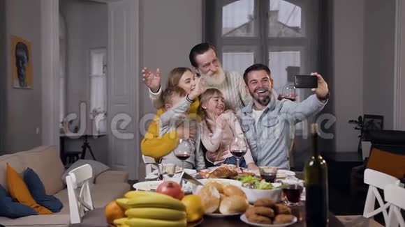 亲密的快乐家庭坐在餐桌旁自拍视频的预览图