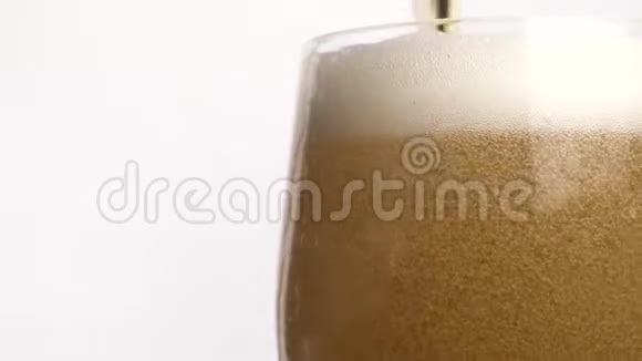 在装有水滴的杯子里喝冷光啤酒用慢动作的泡沫接近啤酒视频的预览图