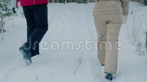 一对夫妇在冬天的森林里一起在雪地里散步视频的预览图