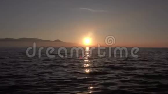 秋季多云间阴日落海波傍晚日落和日射线观视频视频的预览图