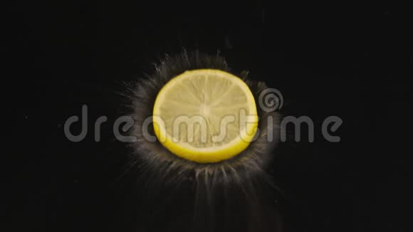 成熟的多汁的柠檬片落在覆盖着水的黑色表面上慢动作视频的预览图
