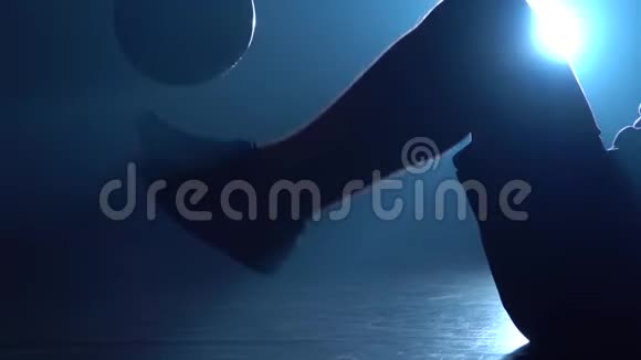 特写运动员腿在地板上填充球对抗蓝色聚光灯慢动作视频的预览图
