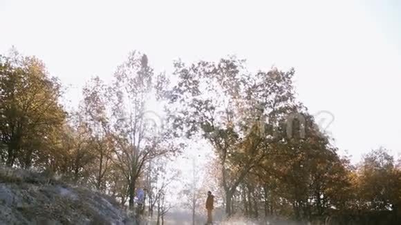 一个女孩在一个寒冷的早晨跑到山上跳进她男朋友的怀里视频的预览图