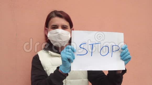 佩戴白色标志的女士禁止佩戴白色健康面罩和蓝色医生手套以对抗病毒型冠状病毒或视频的预览图