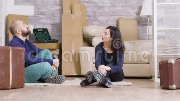 一对夫妇坐在新公寓的地毯上视频的预览图