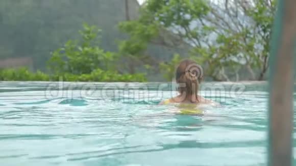 带马尾辫的年轻女子在棕色游泳池游泳视频的预览图