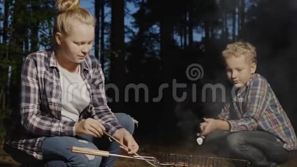 青少年晚上在篝火上煮棉花糖视频的预览图