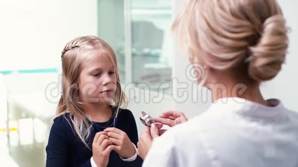 儿科医生正在用听诊器检查他的手指女孩倾听微笑视频的预览图