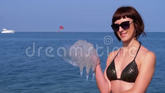 女人拿着一条大海水母在黑海的背景下根瘤菌视频的预览图