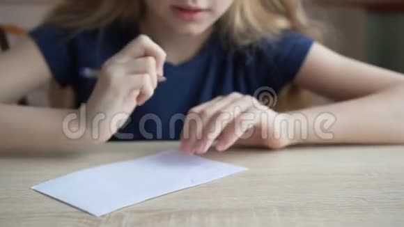学生用钢笔在桌上格子纸上写字把学生女孩写字贴在格子纸上视频的预览图