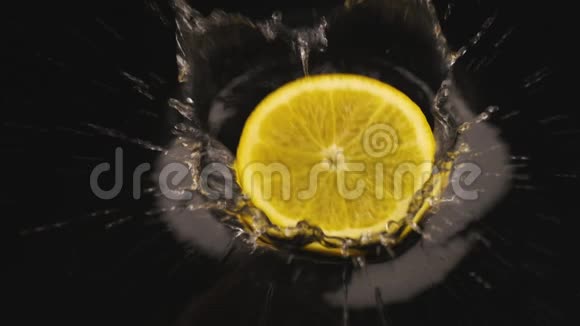成熟多汁的橙色切片落在覆盖着水的黑色表面上慢动作视频的预览图