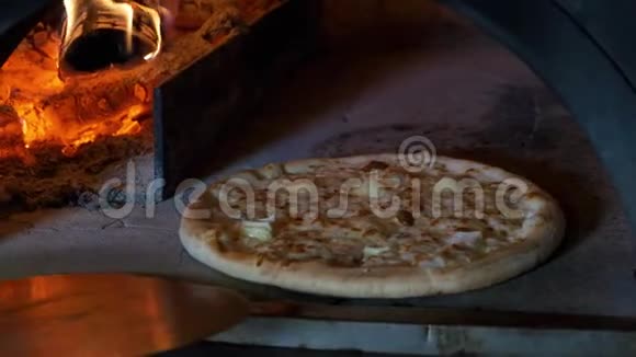 意大利比萨饼和4个奶酪是在烤箱里煮的餐厅厨师把比萨饼放在一个木头烤箱里视频的预览图