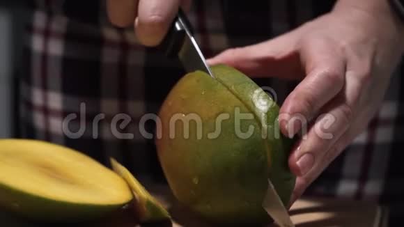 在厨房的木板上用大刀切芒果视频的预览图
