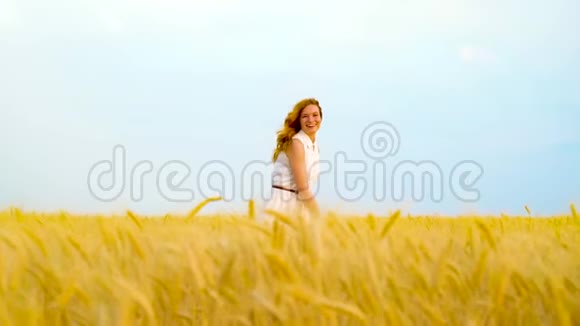 快乐的红发女孩躲在金色麦田里视频的预览图