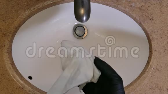 带手套的手清洁卫生间洗手池视频的预览图