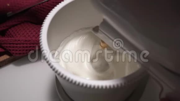 关闭从上往下看搅拌机混合白色奶油蛋糕主厨停止搅拌视频的预览图