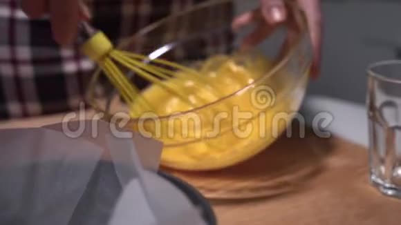 在厨房里用透明的碗打蛋黄准备蛋糕的原料视频的预览图
