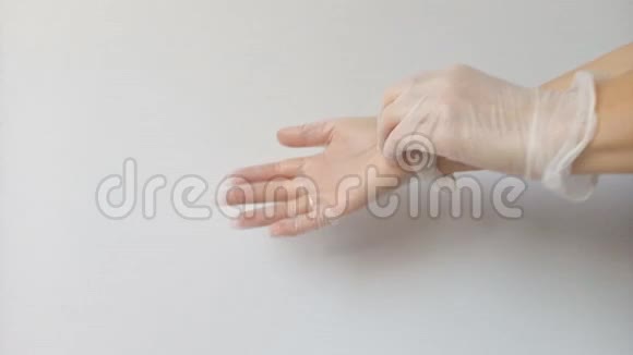 女性手在使用后脱下薄的透明橡胶手套作为保护其健康免受病毒和细菌侵害的一种手段视频的预览图