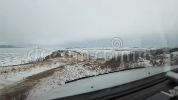从车里看这辆车正在冰上行驶从汽车挡风玻璃到冬天的美丽景色视频的预览图