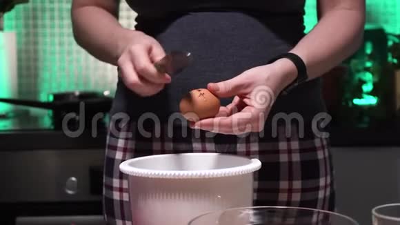 女孩把蛋黄和蛋白质分开然后将蛋黄放入透明碗中一个女人正在准备好吃的视频的预览图