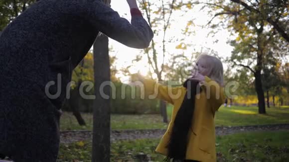快乐的孩子微笑的小女孩在秋天散步时和妈妈玩石头剪刀纸游戏视频的预览图