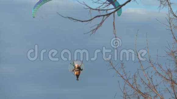 日落时分一个人在城市里用马达驾驶滑翔伞夏季视频的预览图