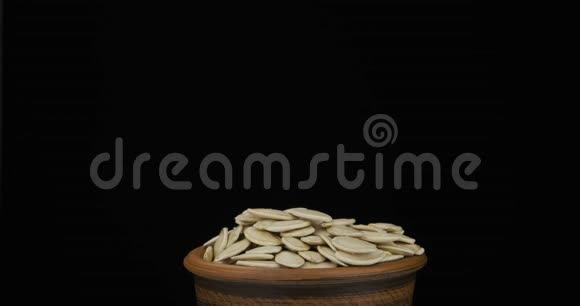 南瓜的全部种子落在一堆种子上躺在一个陶罐里然后从锅里掉出来特写镜头视频的预览图