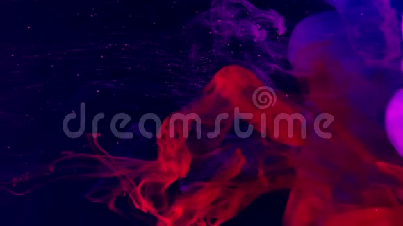 红色蓝色空间背景粉红色水彩墨水在水中的深蓝色背景上视频的预览图