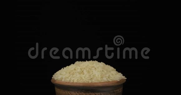 全粒大米落在一堆谷物上躺在泥锅里从锅里掉出来特写镜头视频的预览图