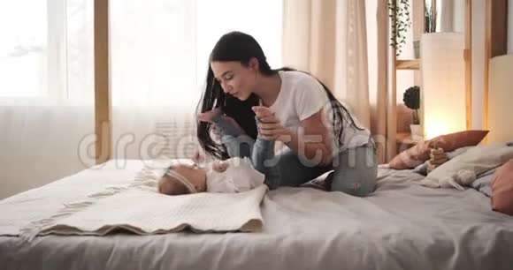 妈妈在床上轻轻地吻着小女儿视频的预览图