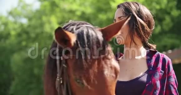 美丽的女人抚摸和抚摸一匹棕色的马朋友意大利旅行在翁布里亚4k慢动作视频的预览图