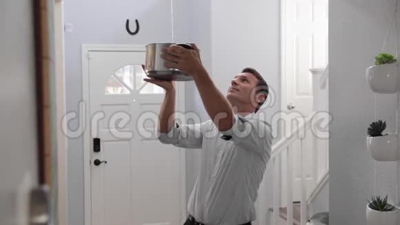 一个人拿着一个壶水从天花板上流出来视频的预览图