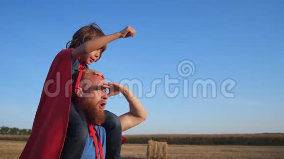 爸爸和儿子肩并肩穿过田野视频的预览图