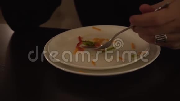 一只雄性手用叉子从白色盘子里收集剩下的食物剩下的蔬菜沙拉在盘子里男人吃视频的预览图