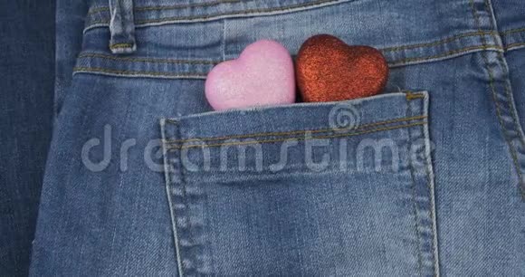 全景两颗象征性的心从牛仔裤的后口袋伸出特写情人节视频的预览图