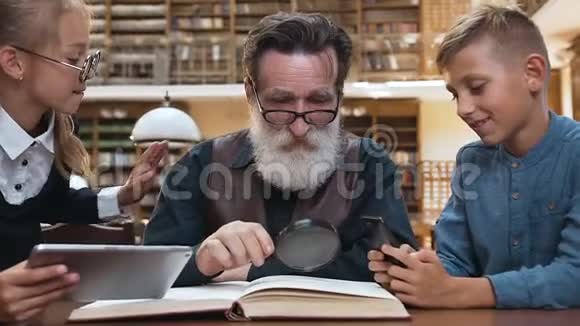受人尊敬的70岁留着胡须的人不喜欢因为12岁的孙辈在现代设备上玩耍而不是读书视频的预览图
