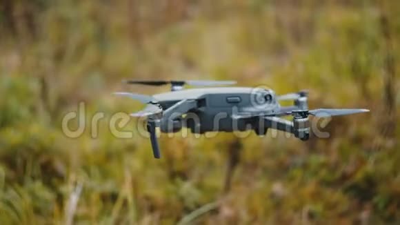 近距离的年轻休闲白人男子正在测试无人驾驶飞机悬挂在空中的秋天中旬森林视频的预览图