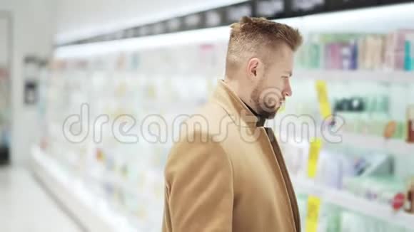 穿棕色外套的年轻人在化妆品商店选择商品购物理念视频的预览图