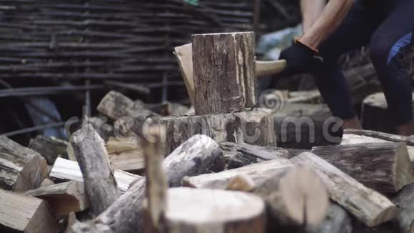 人们在户外缓慢地砍柴人手拿斧子樵夫用斧子砍树干视频的预览图
