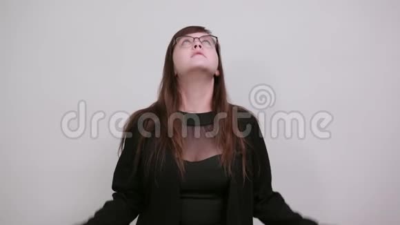 年轻女子穿着漂亮的便服抬起手指抬起头来视频的预览图