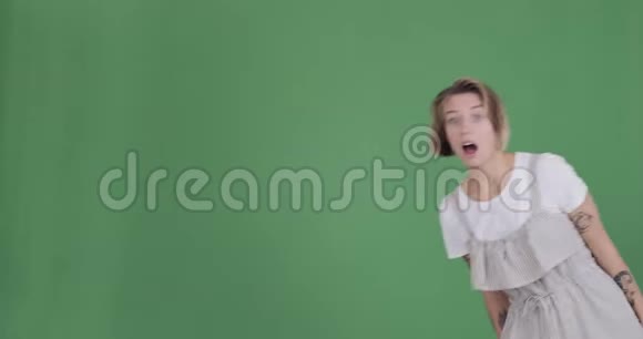 女人竖起大拇指做手势消失在绿色的背景上视频的预览图